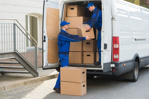 Mover carrying household items near a typical Hillingdon home